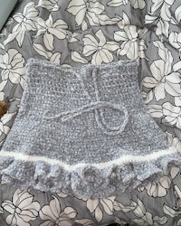 a grey crocheted skirt on a bed